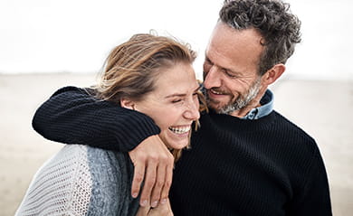 Happy couple hugging on the beach 